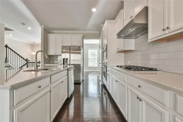 a kitchen with white cabinets and appliances