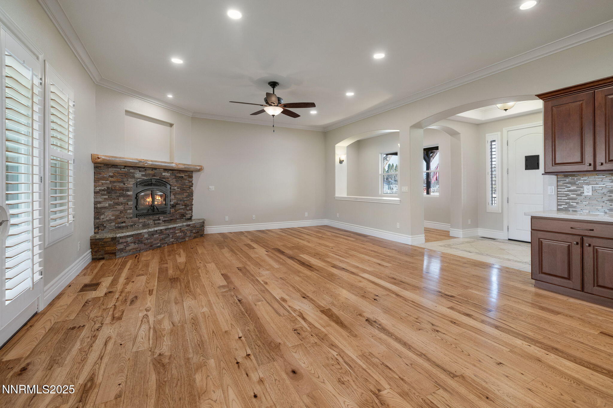 505 Sierra Manor Drive Reno, NV 89511 - Photo 12 of 36 an empty room with wooden floor fireplace and windows