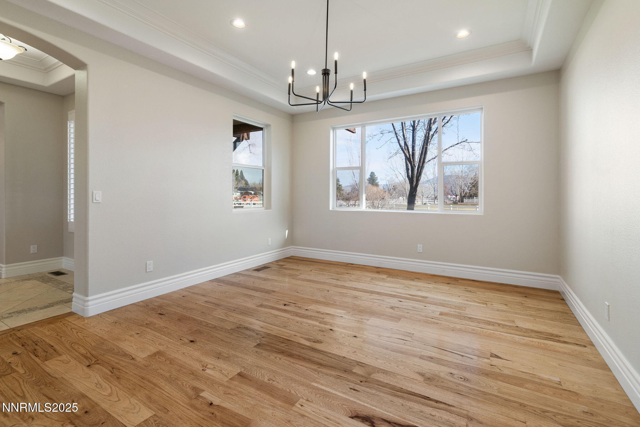 505 Sierra Manor Drive Reno, NV 89511 - Photo 14 of 36 an empty room with wooden floor chandelier and windows