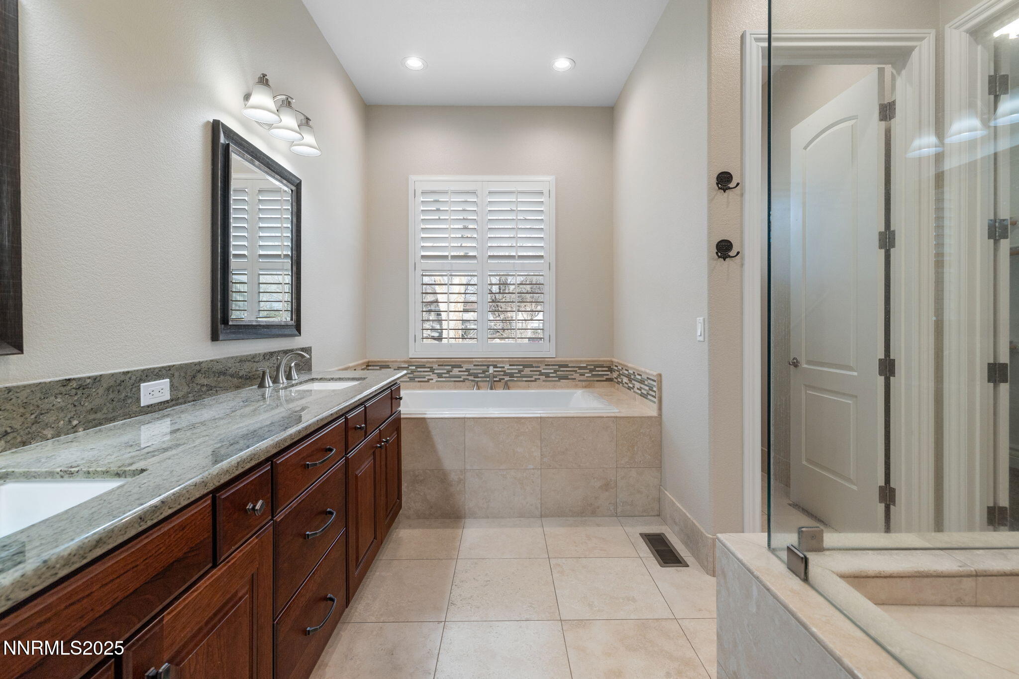 505 Sierra Manor Drive Reno, NV 89511 - Photo 17 of 36 a bathroom with a granite countertop bathtub a sink and a large mirror