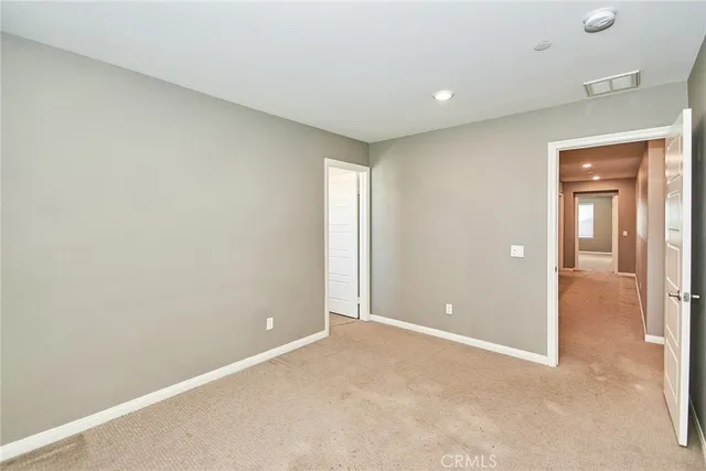 an empty room with closet area and bathroom
