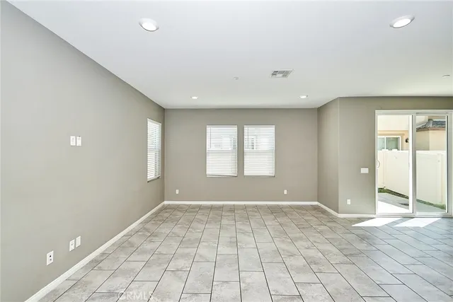 a view of an empty room with window and a bathroom