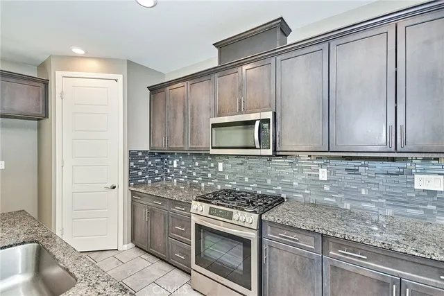 a kitchen with granite countertop a sink and a stove