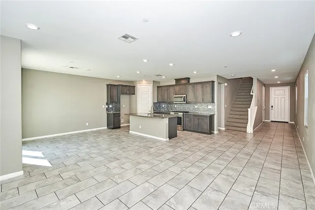 a view of kitchen with stainless steel appliances granite countertop a stove a sink and a refrigerator