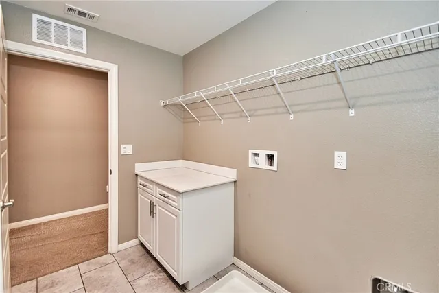 a utility room with cabinets washer and dryer