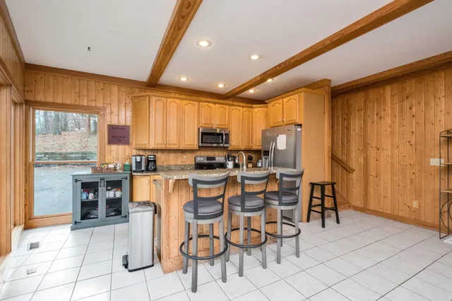 a large kitchen with granite countertop a large counter top stainless steel appliances and cabinets
