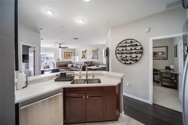 a kitchen with stainless steel appliances a refrigerator a stove a sink and a island with wooden floor