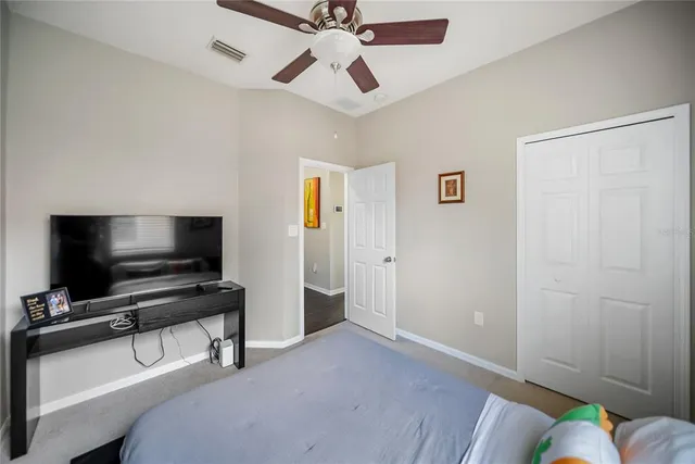 a view of a hallway with wooden floor and a bathroom