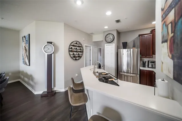 a kitchen with stainless steel appliances a refrigerator a stove top oven a dining table and chairs