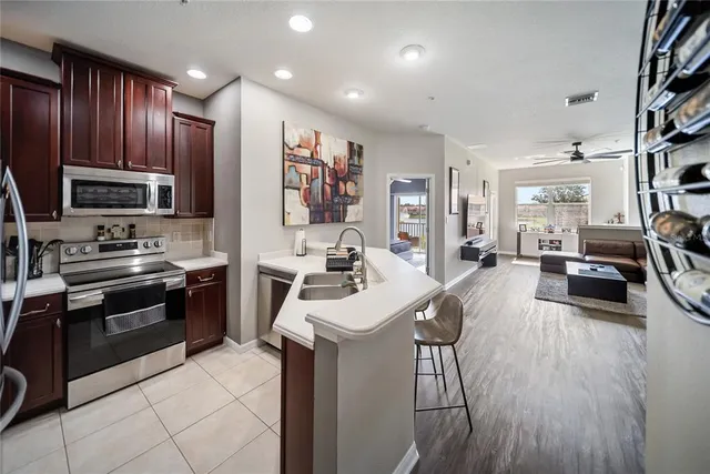 a kitchen with stainless steel appliances kitchen island granite countertop a stove sink and cabinets