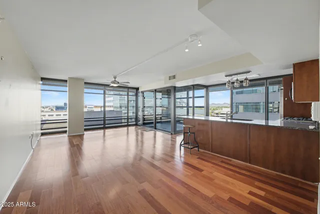 a view of empty room with wooden floor and fan