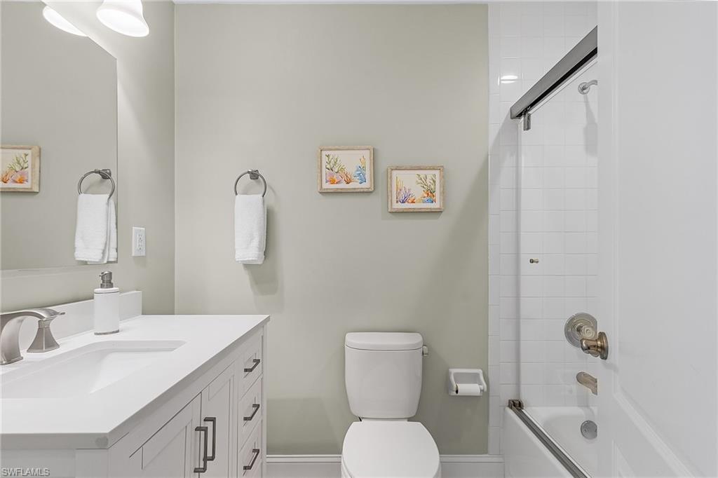 15337 Wimborne Lane, Unit 5 Naples, FL 34110 - Photo 17 of 37 a bathroom with a toilet sink vanity tub and mirror