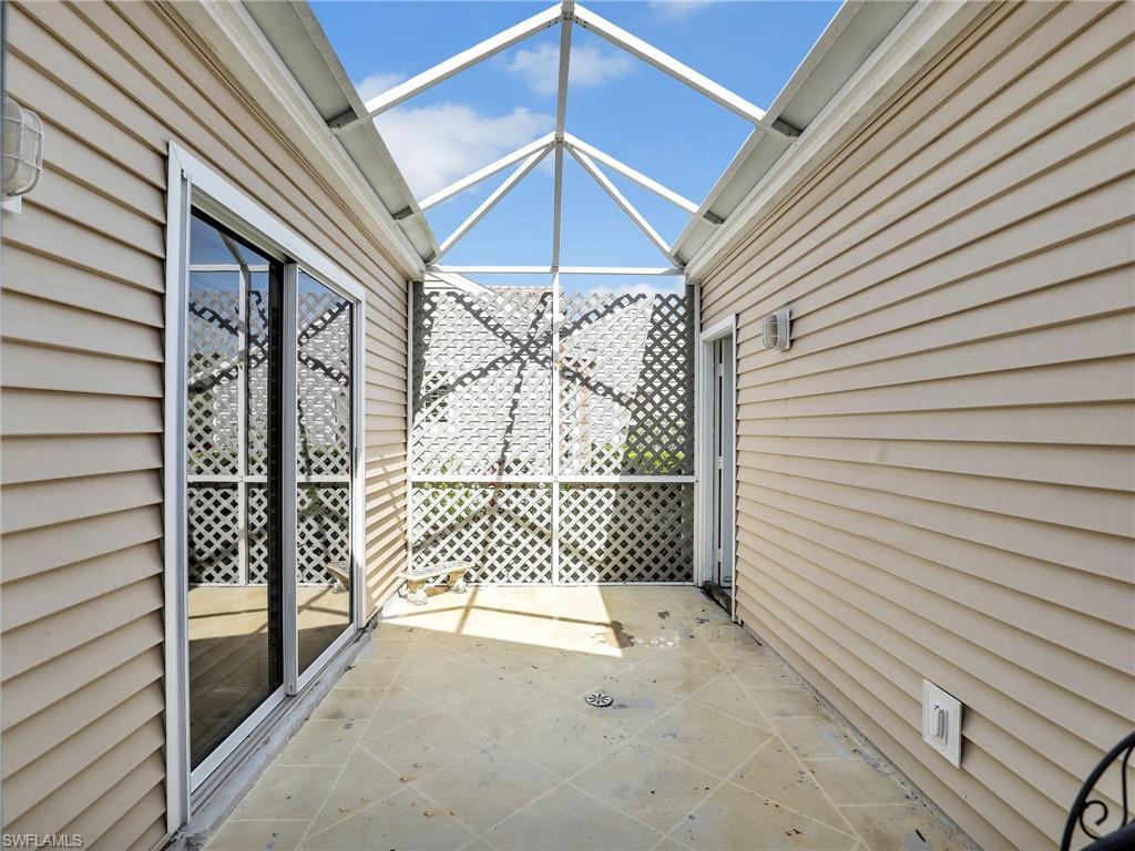15337 Wimborne Lane, Unit 5 Naples, FL 34110 - Photo 23 of 37 a view of a house with a door and wooden walls