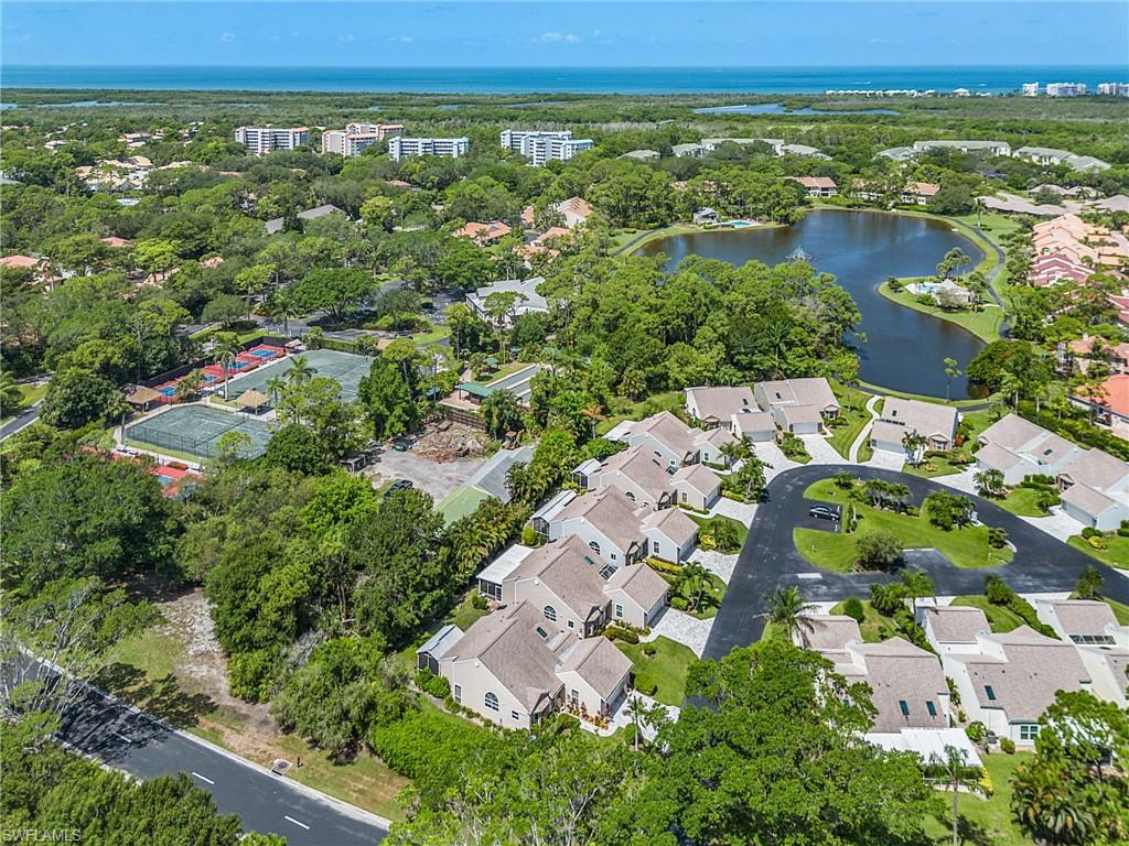 15337 Wimborne Lane, Unit 5 Naples, FL 34110 - Photo 31 of 37 an aerial view of residential houses with outdoor space and trees