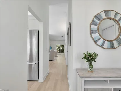 a kitchen with stainless steel appliances granite countertop a stove top oven a sink dishwasher and a refrigerator with wooden floor