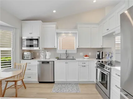 a kitchen with white cabinets and white appliances