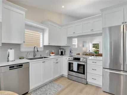 a kitchen with kitchen island a sink a counter top space and cabinets