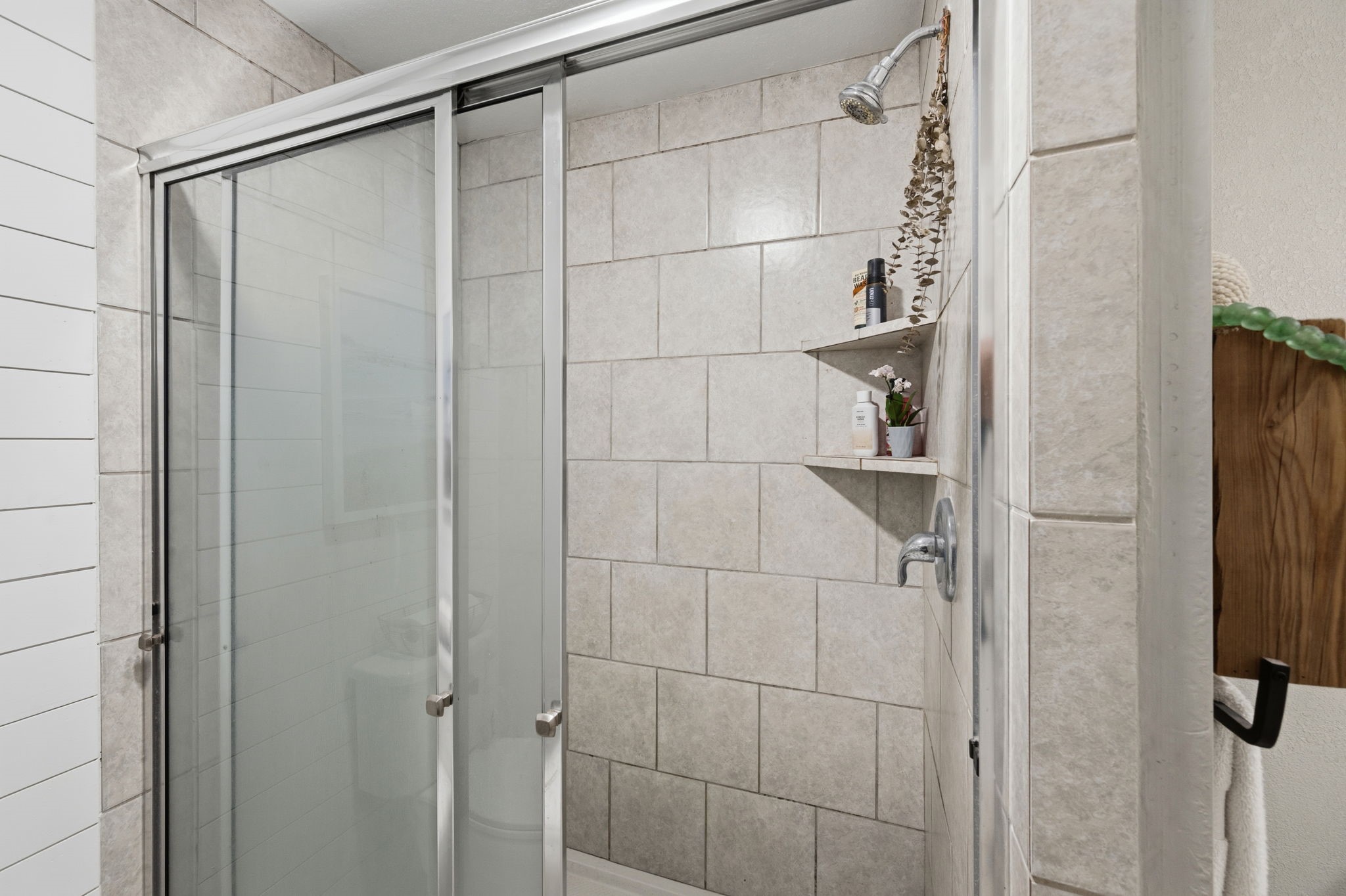 431 Corydon Drive Houston, TX 77336 - Photo 18 of 26 Updated shower with neutral tile surround, sliding glass doors, and built-in shelving for convenient storage.