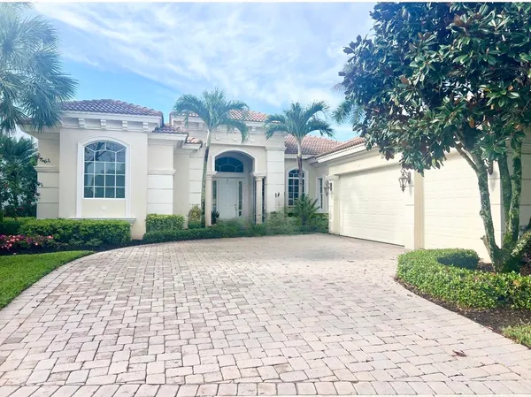 a front view of a house with yard and parking