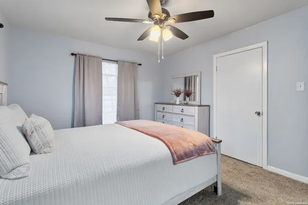 a bedroom with a large bed and a chandelier