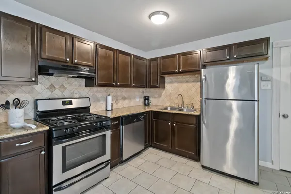 a kitchen with stainless steel appliances granite countertop a refrigerator stove a sink and dishwasher