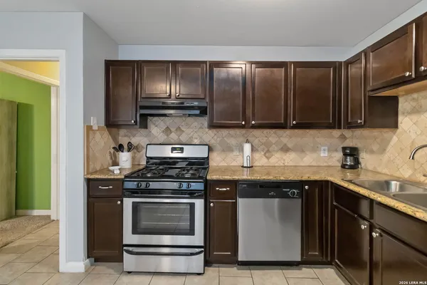 a kitchen with granite countertop wooden cabinets and stainless steel appliances
