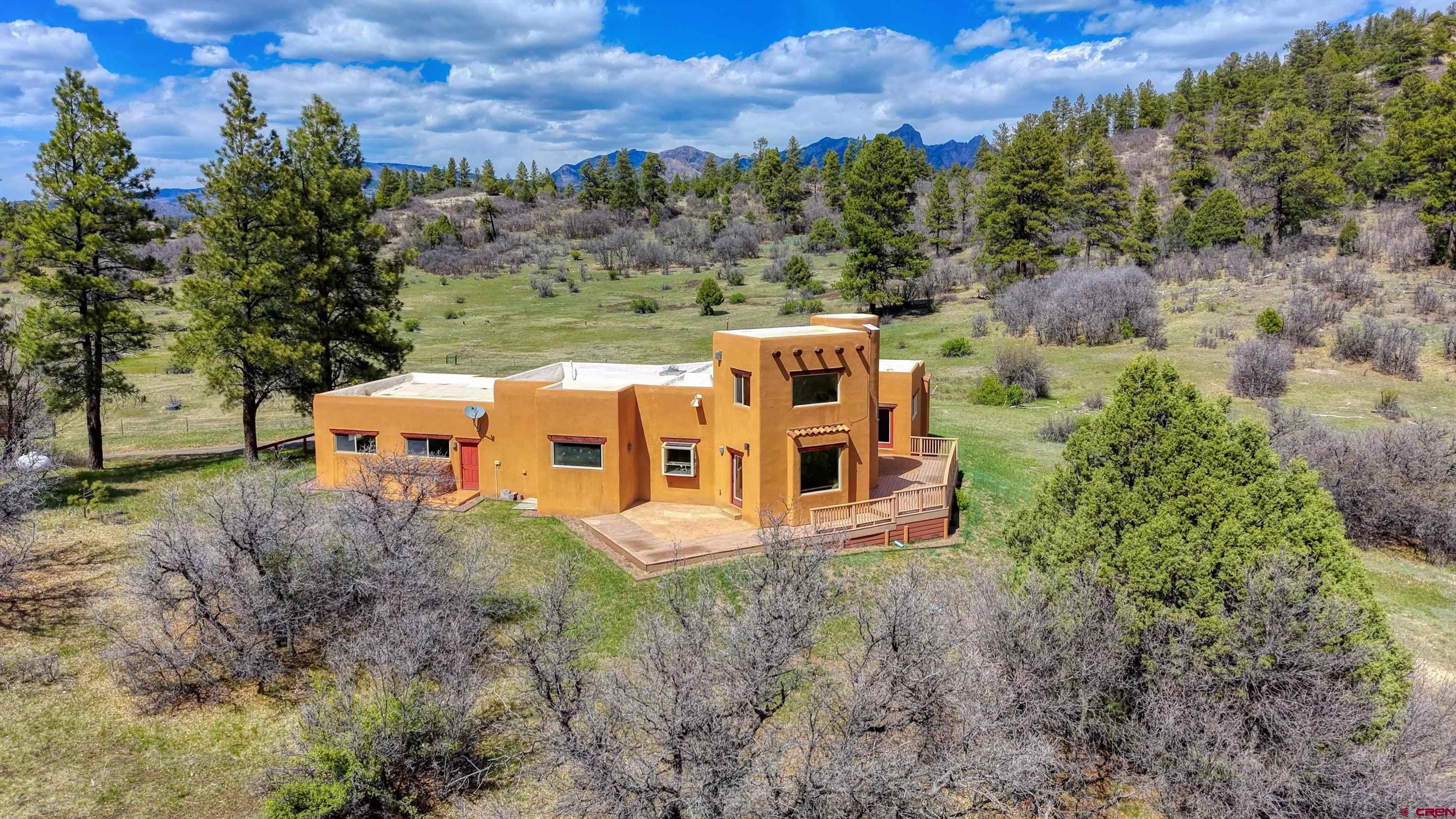 719 Spring Creek Circle Chromo, CO 81128 - Photo 1 of 45 an aerial view of a house with a yard and large tree