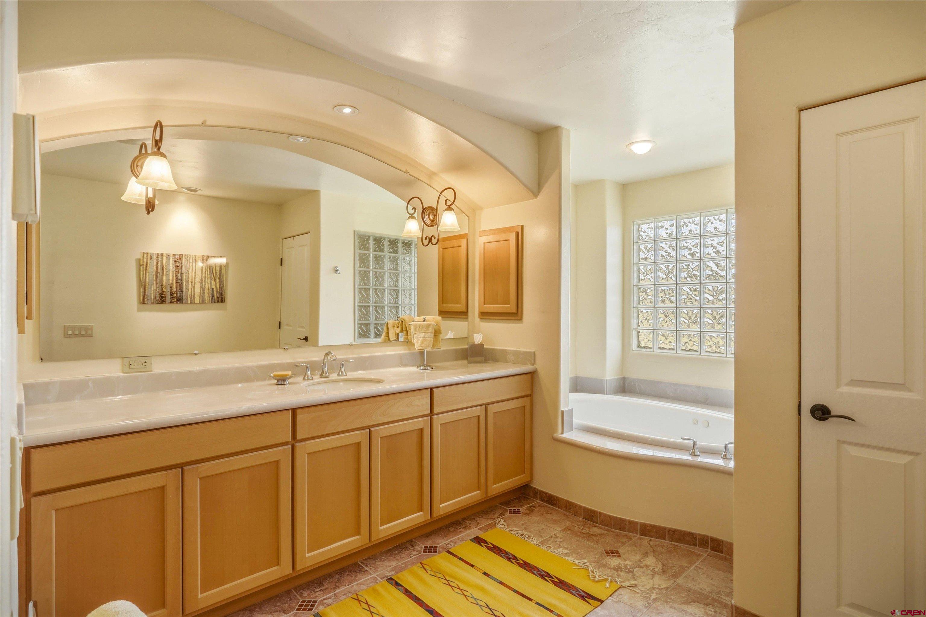 719 Spring Creek Circle Chromo, CO 81128 - Photo 20 of 45 a spacious bathroom with a shower sink and mirror