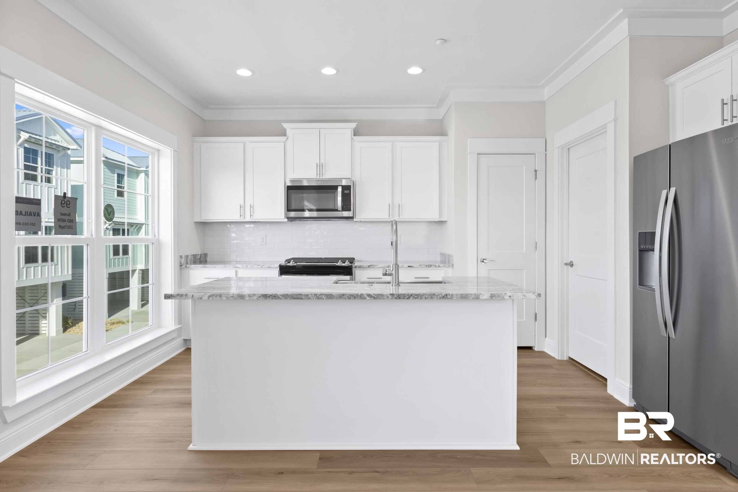 2847 Salt Drive Orange Beach, AL 36561 - Photo 10 of 29 Kitchen with white cabinets, an island with sink, and appliances with stainless steel finishes