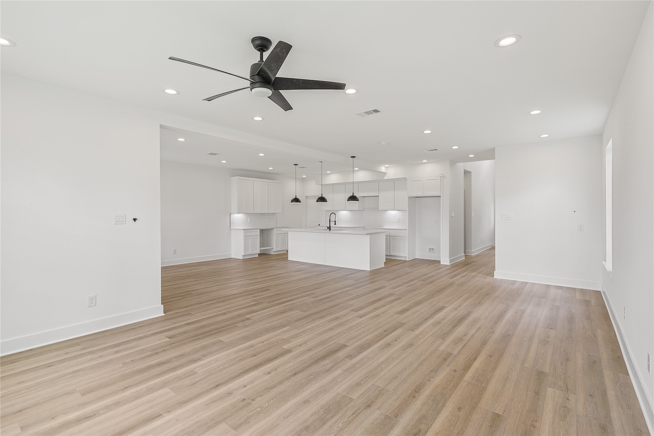 7411 Charlie Street Houston, TX 77088 - Photo 6 of 25 a view of an empty room with wooden floor and a ceiling fan
