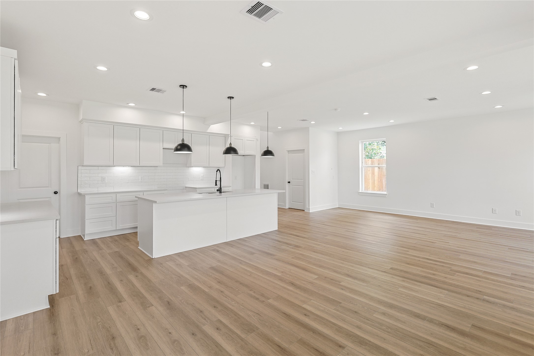 7411 Charlie Street Houston, TX 77088 - Photo 7 of 25 a large kitchen with kitchen island a sink stainless steel appliances and cabinets