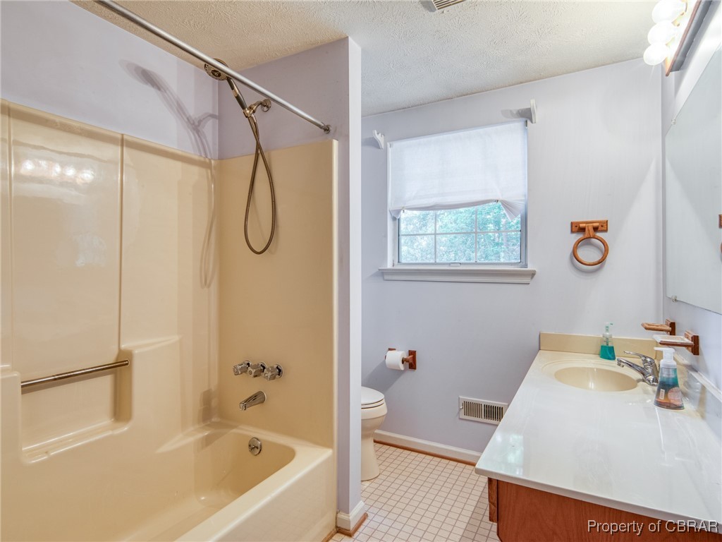 6 Ruth Circle Hampton, VA 23666 - Photo 35 of 50 Full bathroom featuring a textured ceiling, toilet, vanity, tile patterned flooring, and shower / tub combination