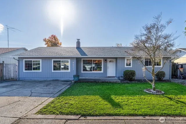 a front view of a house with a yard and potted plants