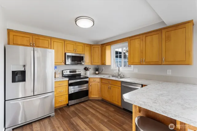 a kitchen with stainless steel appliances granite countertop a stove a sink dishwasher a refrigerator and a microwave