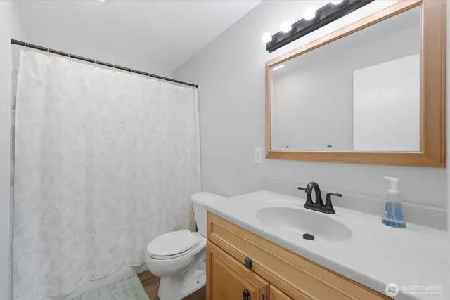 a bathroom with a sink a toilet and a mirror