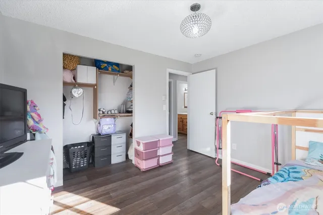 a spacious bedroom with a bed and a flat screen tv