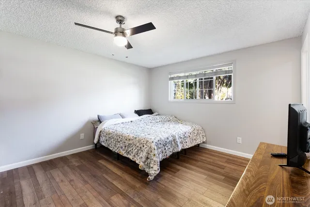 a bedroom with a bed and a flat tv screen on a dresser