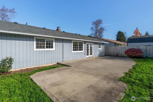 a front view of a house with a yard and potted plants