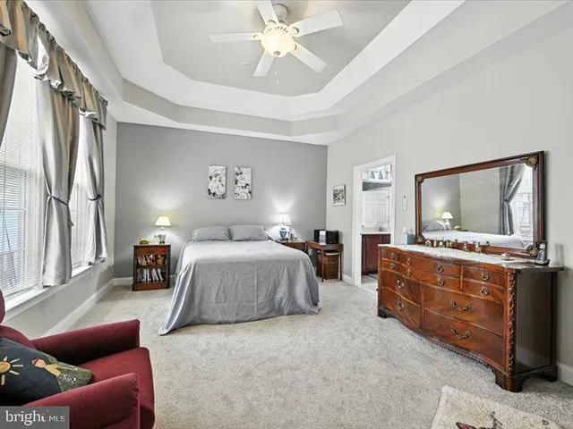 a spacious bedroom with a bed and dresser