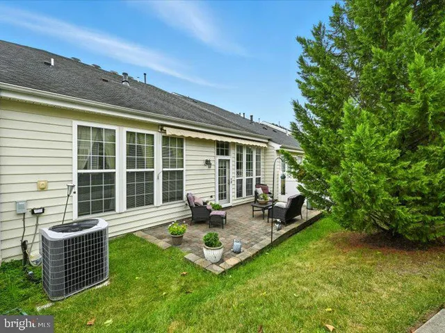 a front view of a house with sitting area and garden
