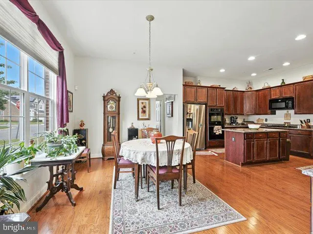 a view of a dining room and livingroom with furniture wooden floor a chandelier