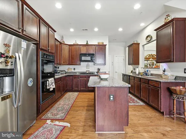 a kitchen with stainless steel appliances granite countertop a stove top oven a refrigerator a sink and dishwasher