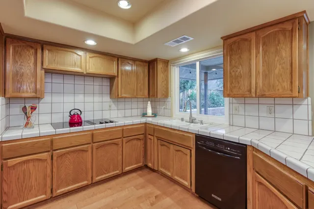 a kitchen with cabinets a window and stainless steel appliances