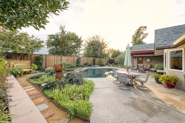a view of swimming pool with outdoor seating and plants