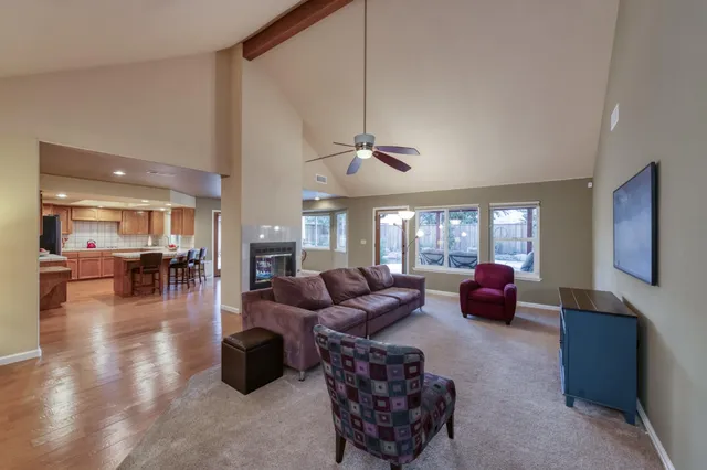 a living room with furniture large window and wooden floor