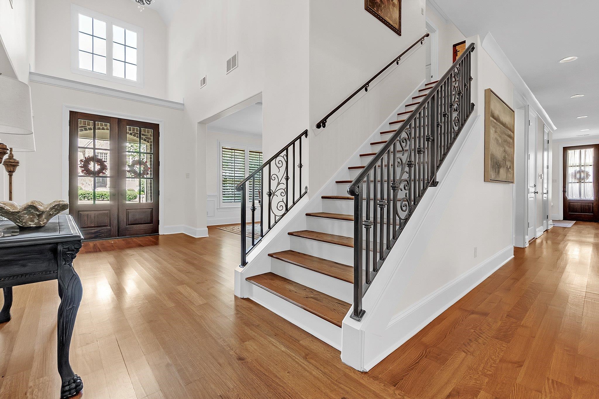 3246 North Hartwell Ridge Drive Collierville, TN 38017 - Photo 6 of 40 Grand foyer featuring wood-finish flooring, a prominent staircase with decorative iron balusters, a double-door entry with glass panels, a transom window, and tall ceilings