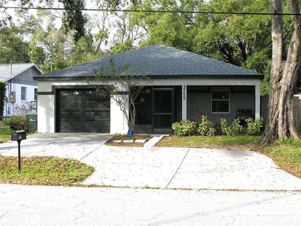 a front view of a house with a yard and potted plants