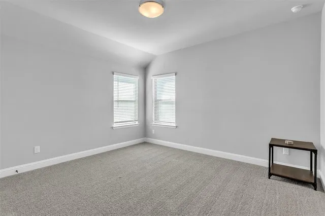 an empty room with windows and cabinet