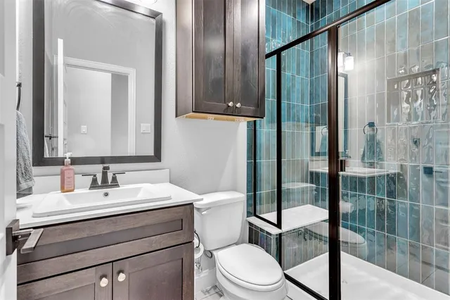 a bathroom with a toilet a sink and glass door
