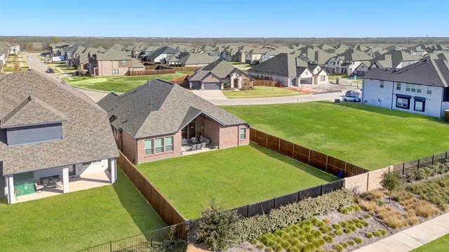 an aerial view of a house with a garden and lake view